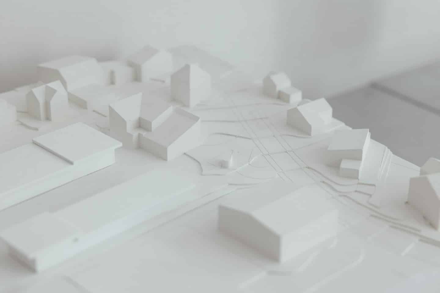 Maqueta arquitectónica blanca de planificación urbana con edificios y carreteras.